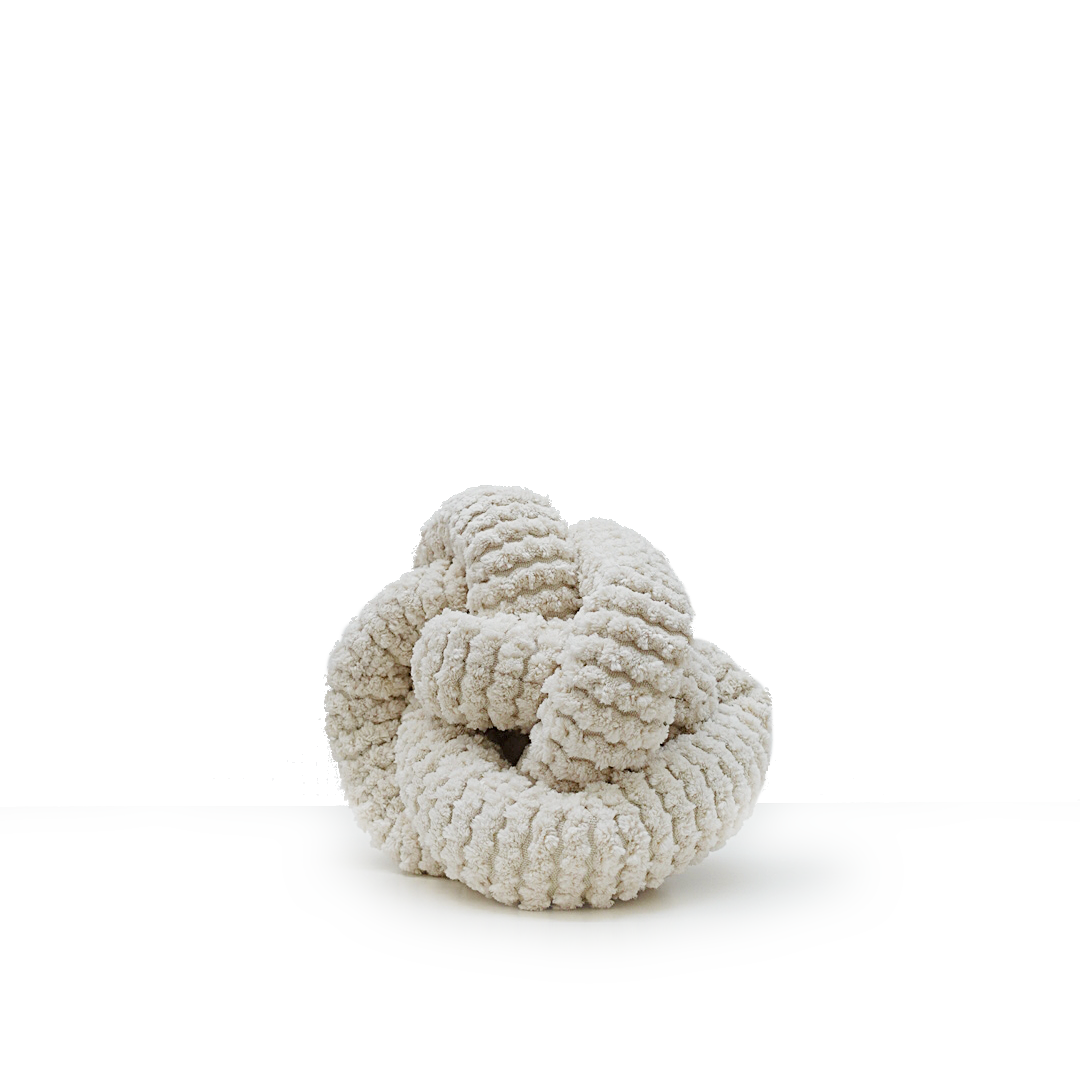 Textured white sculpture forms an intricate knot on a white pedestal.