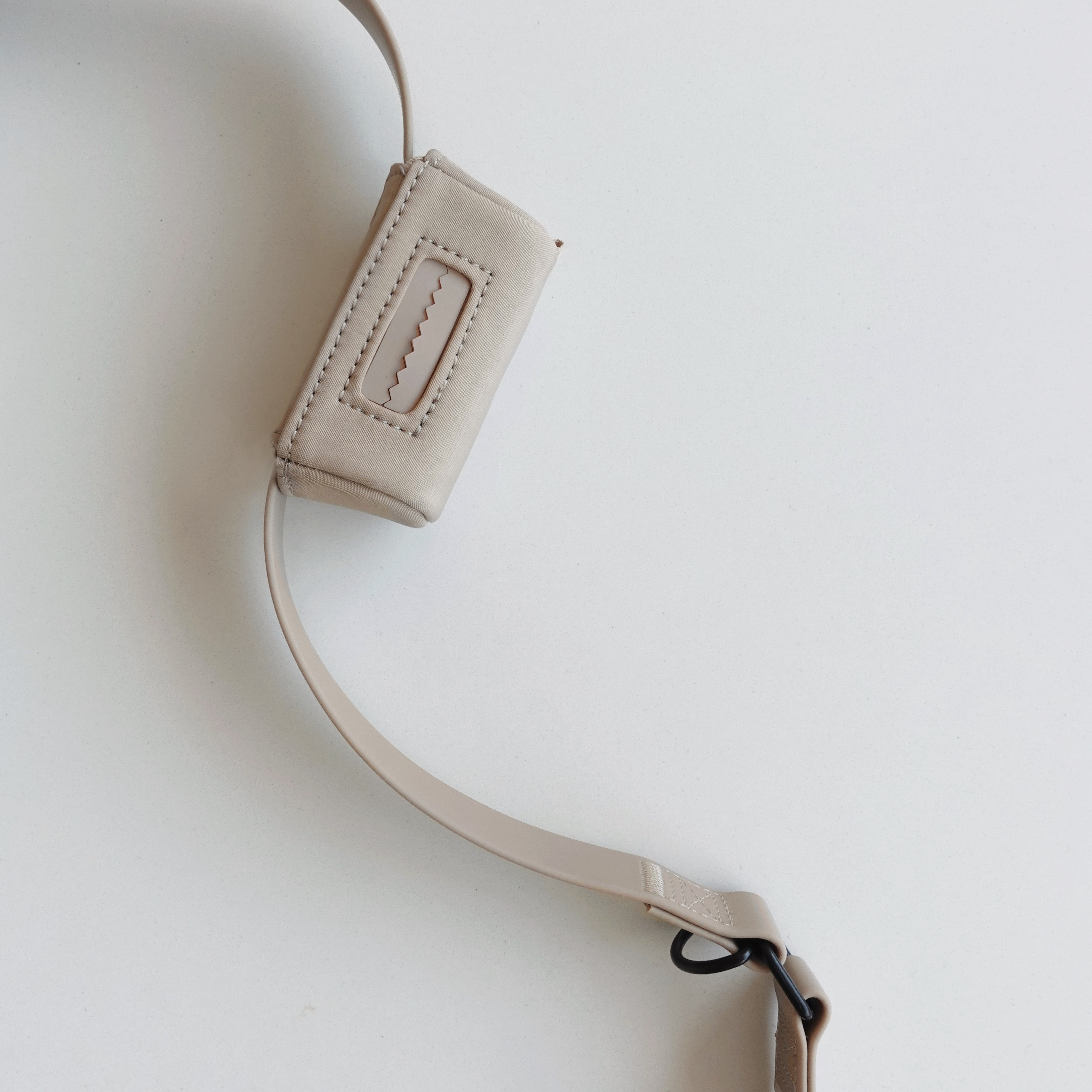 Beige crossbody bag strap with adjustable buckle and stitched detail. 
